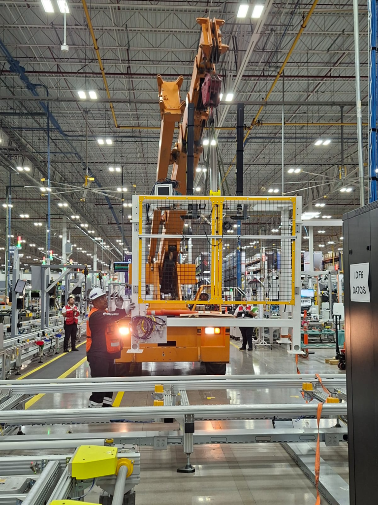 Izaje y Rigging de Precisión en San Luis Potosí Grúa carry deck Broderson posicionando un marco de seguridad amarillo de 1200 kg en línea de producción automotriz.