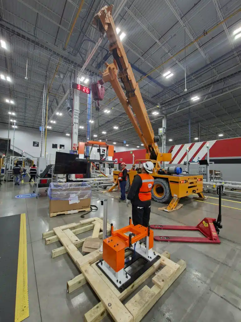 Izaje y Rigging de Precisión en San Luis Potosí Operadores de SEIL realizando izaje de estructura naranja de 800 kg con grúa Broderson en planta automotriz de San Luis Potosí.